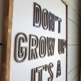 Don't grow up it's a trap wood sign